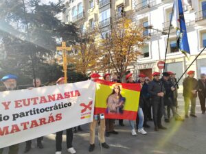 Foto de personas concentradas con pancarta reinvindicativa a favor de la vida "aborto y eutanasia, no matarás" pone en la pancarta y con bandera de España con maría ilustrada.